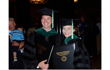 Shane Speights and Amanda Deel stand together in graduation attire with diplomas.